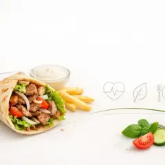 Kebab w picie z mięsem, warzywami, frytkami i sosem, obok świeże warzywa i ikony zdrowia.
