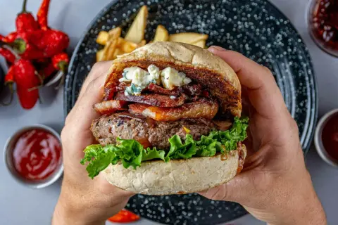 Pyszny domowy burger z serem pleśniowym i boczkiem. Idealny przepis na to, jak zrobić domowe burgery, które zachwycą każdego.